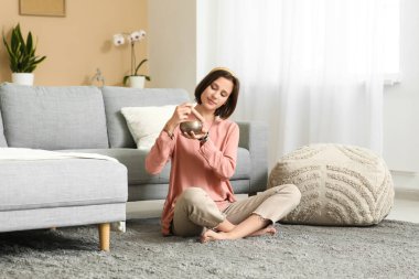 Young woman with Tibetan singing bowl meditating  at home