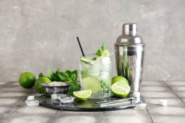 Bir bardak taze mojito kokteyli. Limonlu ve sallanan gri fayanslı.