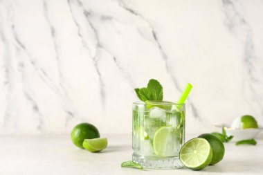 Beyaz arka planda limonlu ve naneli taze mojito kokteyli.