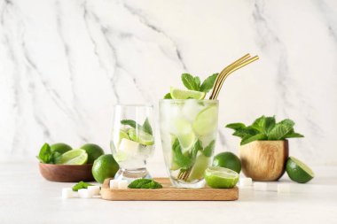 Beyaz arka planda taze mojito kokteyli ve nane şekeri.