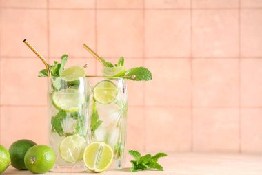 Taze mojito kokteyli, limonlu ve nane şekerli bej masa.