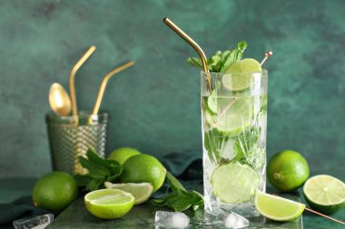 Yeşil arka planda taze mojito kokteyli ve nane şekeri.