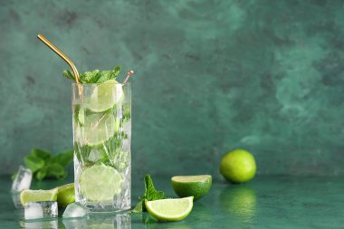 Yeşil arka planda taze mojito kokteyli ve nane şekeri.