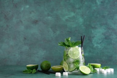Yeşil arka planda taze mojito kokteyli ve nane şekeri.