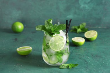 Yeşil arka planda taze mojito kokteyli ve nane şekeri.
