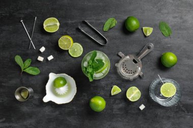 Bir bardak taze mojito kokteyli, limonlu ve siyah arkaplanlı.