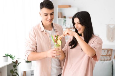 Mutlu genç çift evde mojito için limon suyu sıkıyor.