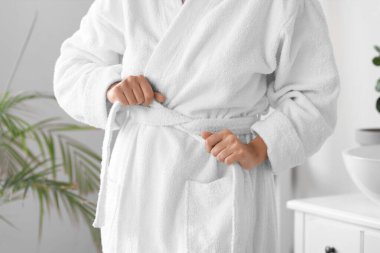 Evde yumuşak bornozlu güzel bir kadın, yakın plan.