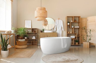 Modern banyonun içinde ev bitkileri ve bornoz asılı.