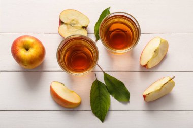 Beyaz ahşap arka planda taze elma suyu bardakları