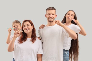 Mutlu aile arka planda dişlerini fırçalıyor.