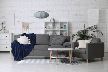 Yumuşak kanepesi, koltuğu ve sehpası olan şık bir oturma odası.