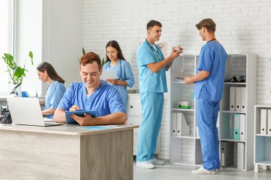 Klinikteki masada pano taşıyan bir erkek doktor.