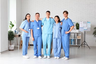 Klinikte sarılan bir grup genç doktor.