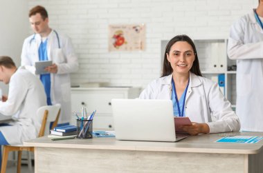 Klinikteki masada çalışan kadın doktor.