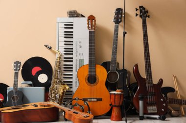 Bej duvarın yanında farklı müzik aletleri