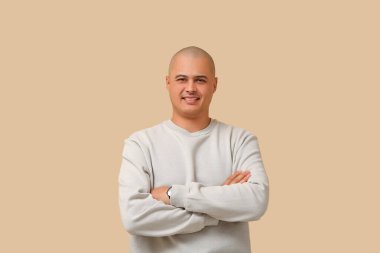 Bej arka plandaki kel genç adam.