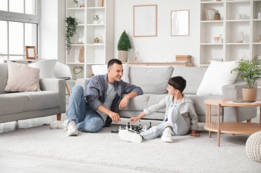 Babasıyla evde satranç oynayan tatlı bir çocuk.