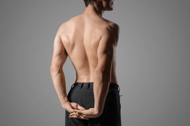 Gri arka planda kaslı genç adam, arka plan