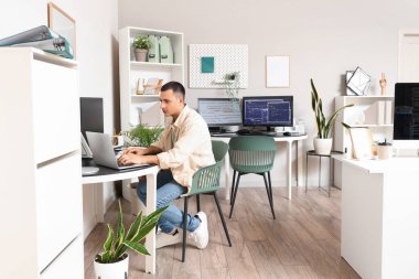 Ofiste dizüstü bilgisayarla çalışan yakışıklı bir programcı.