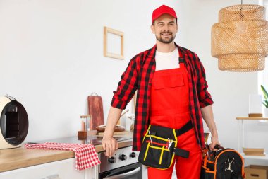 Mutfakta bir çanta alet edevat taşıyan erkek teknisyen.