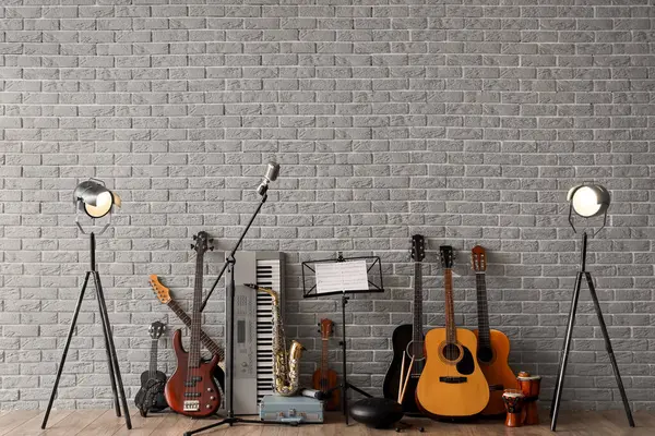 stock image Different musical instruments near grey brick wall