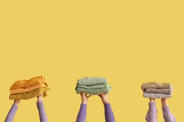 Sarı arka planda katlanmış süveterli kadınlar