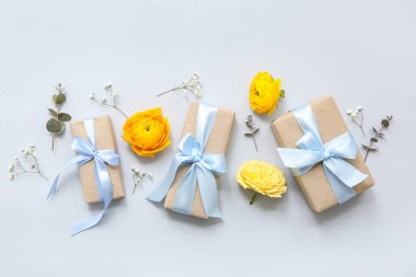 Mavi arka planda çiçekler olan güzel paketlenmiş hediye kutuları.