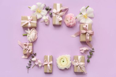 Paketlenmiş hediye kutularından yapılmış çerçeve ve pembe arka planda çiçekler