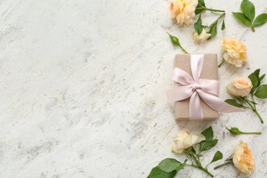 Zarif paketlenmiş hediye kutusu ve arka planda bahar çiçekleri dekoru