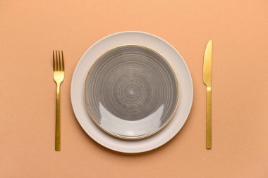 Tablo ayarları ve bej arka planda altın çatal bıçaklar