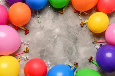 Gri arkaplanda neşeli balonlardan ve ses çıkaranlardan yapılmış çerçeve