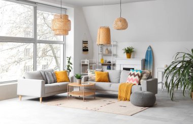 Koltukları, çiçekleri ve kahve masası olan şık bir oturma odası.