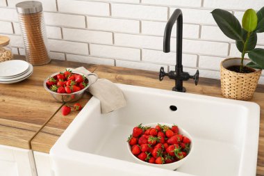 Mutfak lavabosunda lezzetli çilek kasesi.