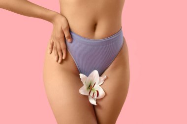 Pembe arka planda beyaz zambak çiçekli külotlu güzel Afro-Amerikan kadın, yakın plan.