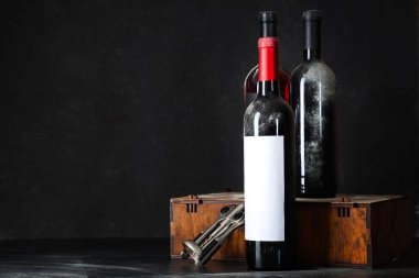 Şarap şişeleri ve siyah grunge arka planda açacağı olan bir kutu.