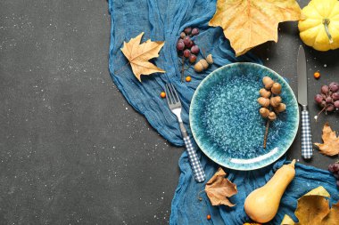Siyah arka planda kabak, kestane, üzüm ve kuru yapraklı sonbahar masası ayarı