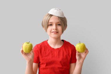 Gri arka planda elmaları olan sevimli küçük bir çocuk. Rosh Hashanah (Yahudi Yeni Yılı) kutlaması