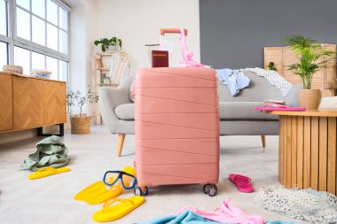 Pasaportlu pembe bavul dağınık oturma odasında