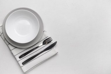 Beyaz arkaplanda temiz tabaklar ve çatal bıçak takımı olan masa ayarları