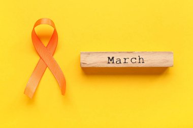 Sarı arka planda marş ve turuncu kurdele. Çoklu Skleroz Farkındalık Ayı