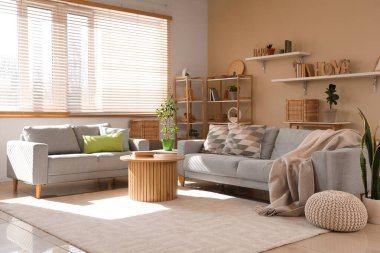 Interior of cozy living room with grey sofas, table and shelf units