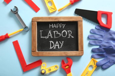 Mesajlı tebeşir tahtası mutlu LABOR Günü ve mavi arka planda oyuncak araçları. İşçi Bayramı kutlamaları