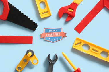 Mesajlı tebrik kartı mutlu LABOR Günü ve mavi arka planda oyuncak araçları. İşçi Bayramı kutlamaları