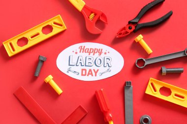 Mesajlı tebrik kartı mutlu LABOR Günü ve kırmızı arka planda oyuncak araçları. İşçi Bayramı kutlamaları