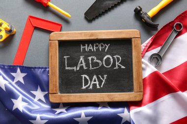 Mesajlı tebeşir tahtası mutlu LABOR Günü, ABD bayrağı ve gri arka planda oyuncak araçları. İşçi Bayramı kutlamaları