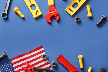 Mavi arka planda Amerikan bayrağı ve oyuncak aletleri. İşçi Bayramı kutlamaları