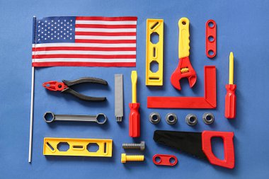 Mavi arka planda Amerikan bayrağı ve oyuncak aletleri. İşçi Bayramı kutlamaları