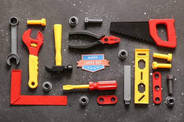 Mesajlı tebrik kartı mutlu LABOR Günü ve gri grunge arka planında oyuncak araçları. İşçi Bayramı kutlamaları