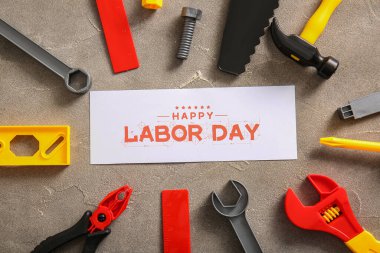 Mesajlı tebrik kartı mutlu LABOR Günü ve gri grunge arka planında oyuncak araçları. İşçi Bayramı kutlamaları